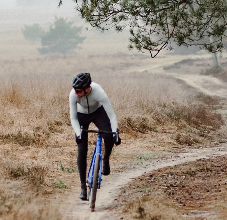 Person cycling on a dirt path in a natural landscape