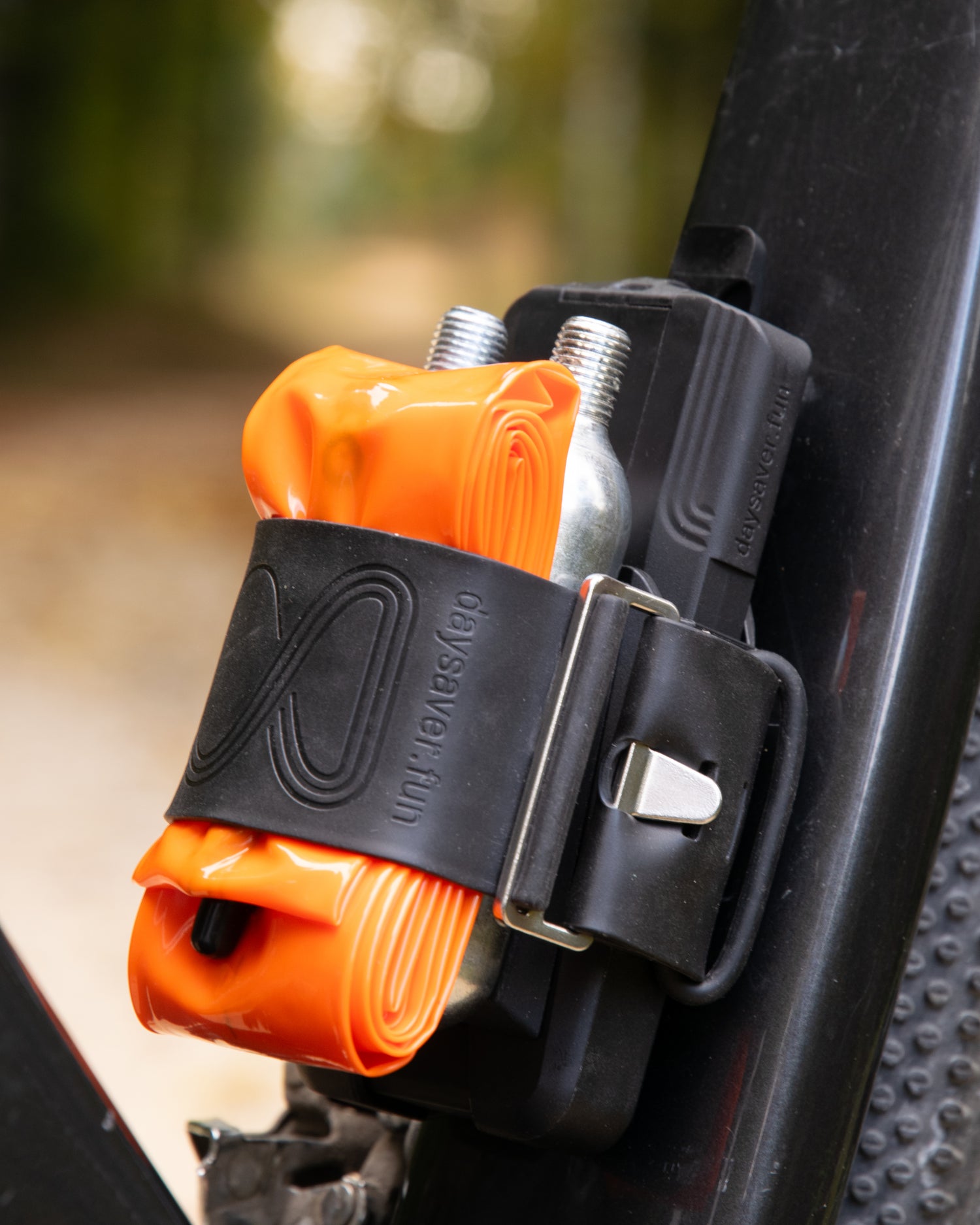 Bike repair kit with orange inflatable tube and black tool on a bike