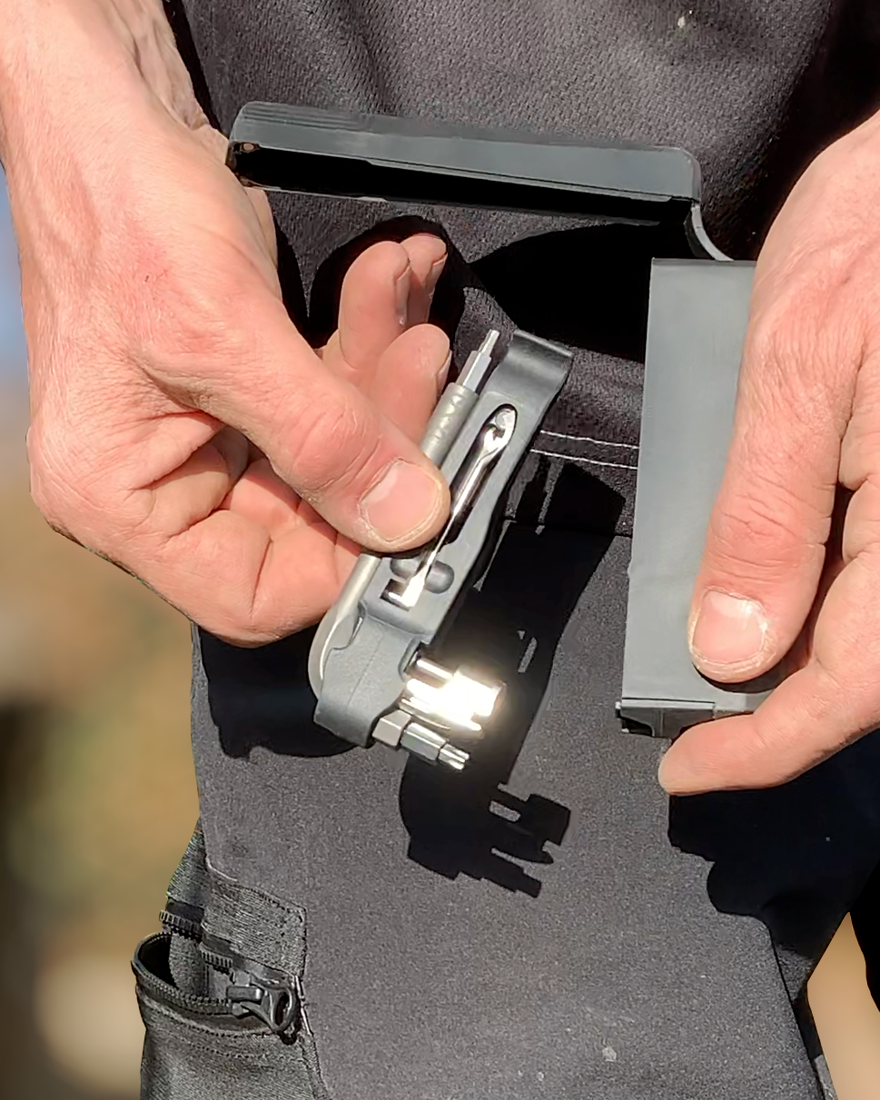 Person holding a gun with a magazine attached, blurred background