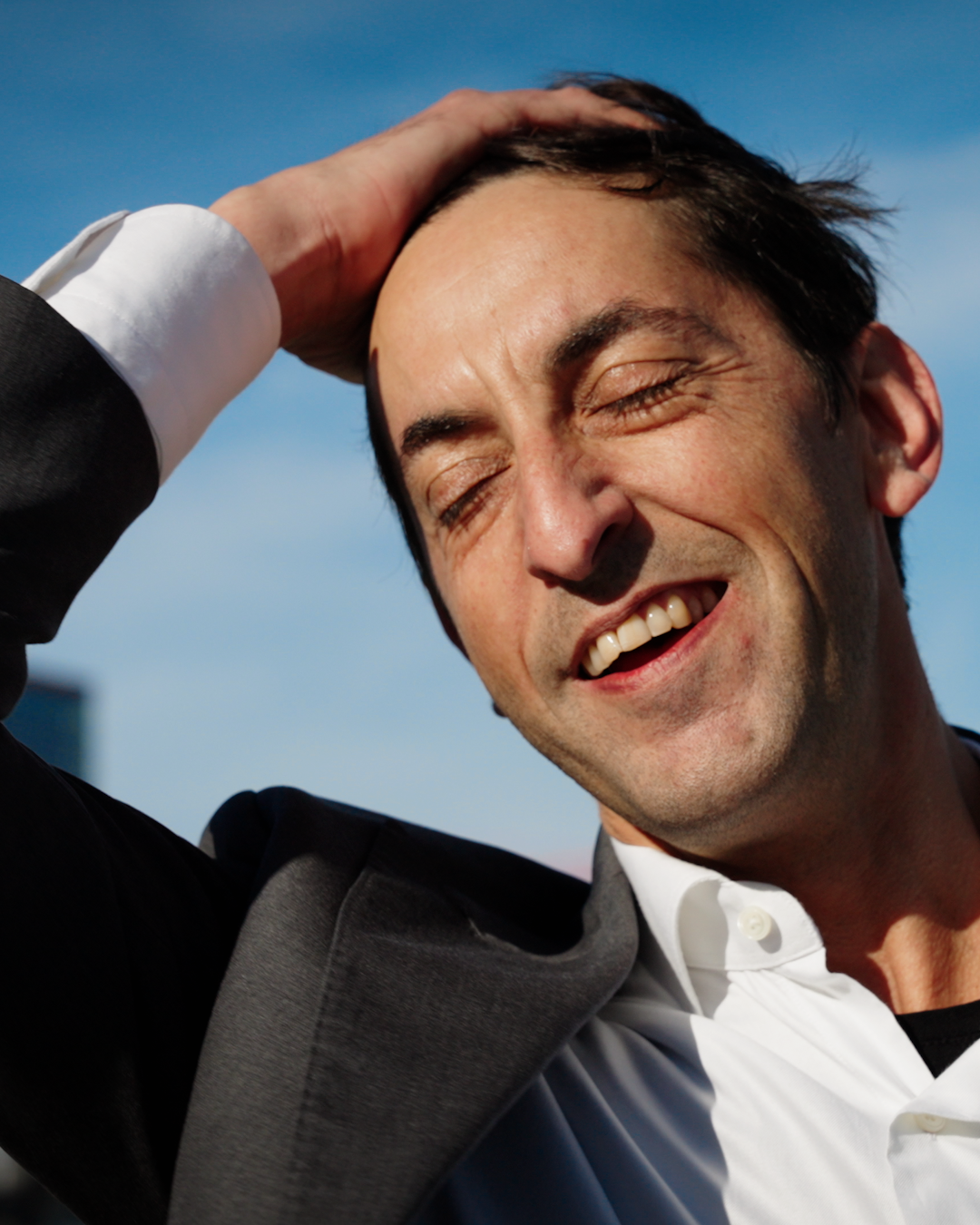 Man with a smile against a blue sky